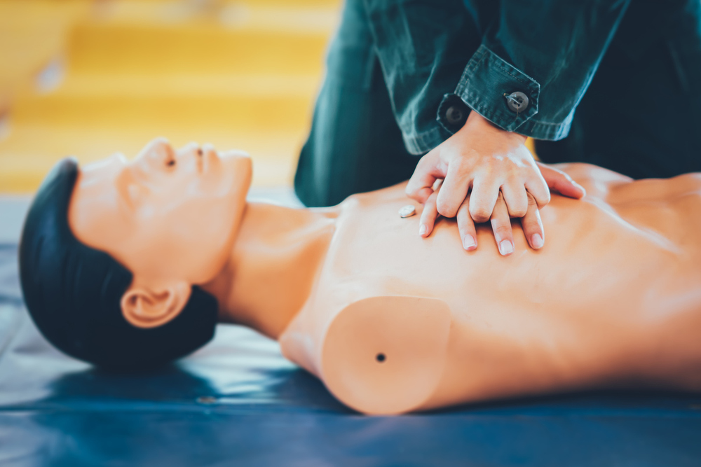 Person applying compressions to CPR dummy