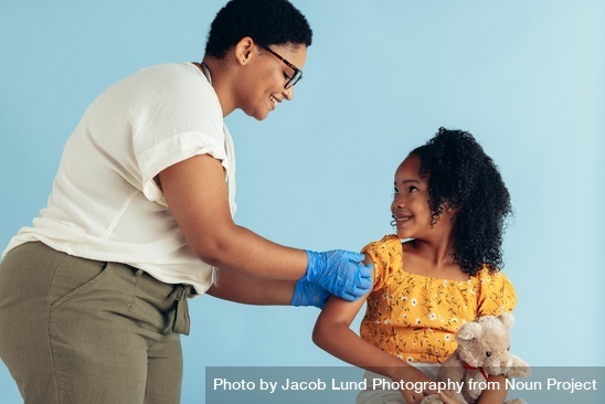 Doctor giving vaccine to small patient
